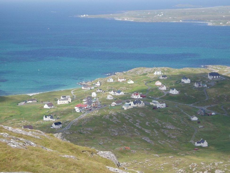 A coastal village with scattered houses and roads near the sea at Eriskay Views Cottage in Eriskay