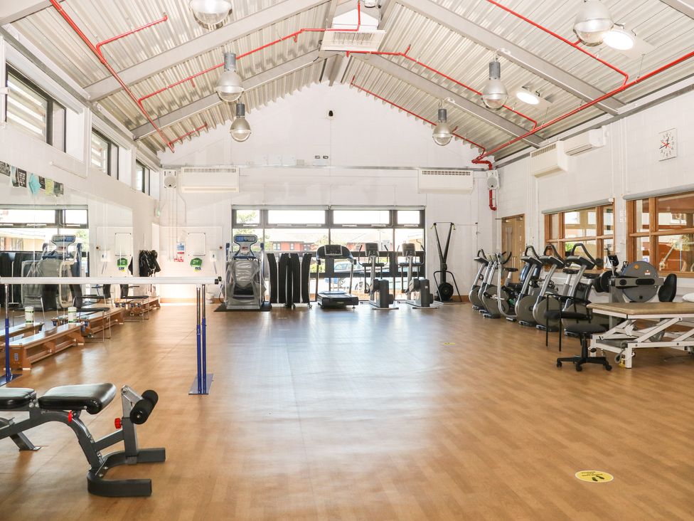 A fitness room with exercise machines benches and mirrors at Flat 34 - Marine Court in Littlehampton