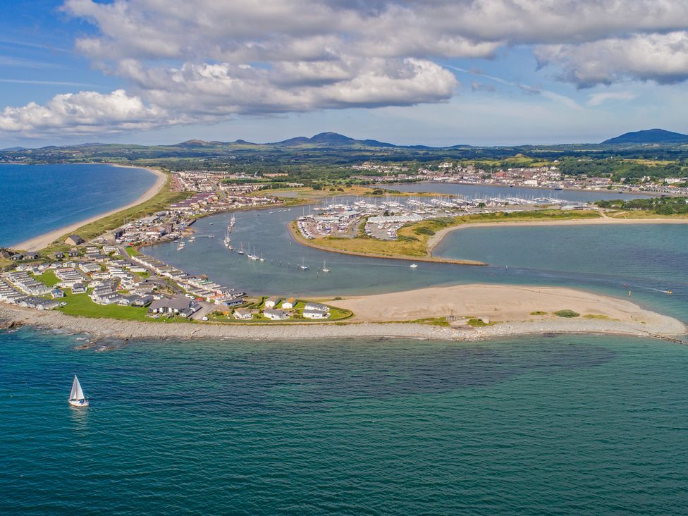 A coastal town with houses marina and a sailboat on the water in Llangybi near Pwllheli