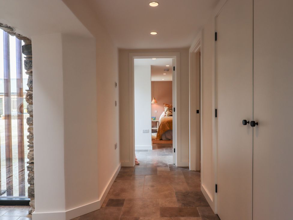 A hallway with tile flooring leading to a bedroom at 3 Caddaford Barns in Buckfastleigh