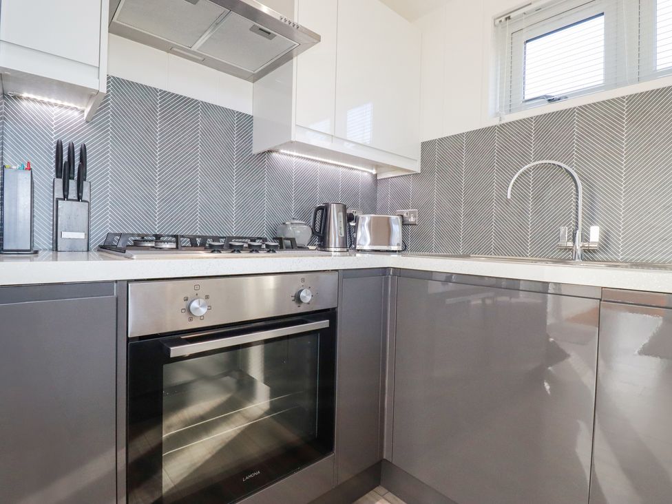 A modern kitchen with a gas stove oven kettle toaster and knife block at 11 Meadow Retreat in Dobwalls