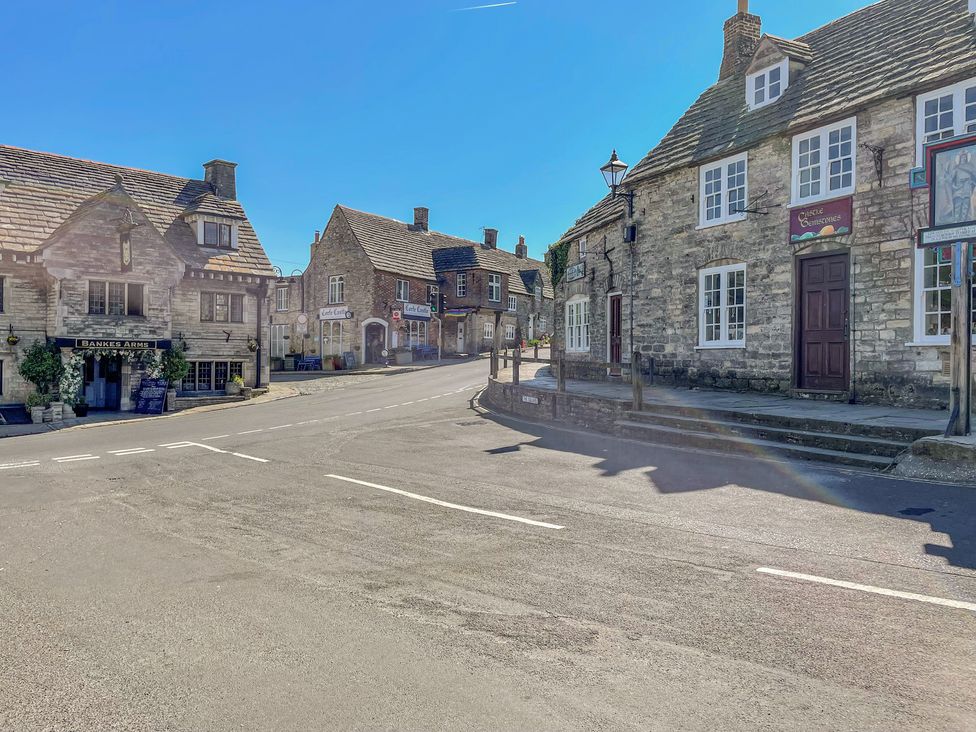 A street with stone buildings and shops under a clear sky at Lodge 6 in Corfe Castle