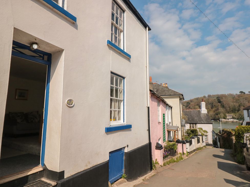 A street view showing houses with one open door and a distant river at Dart Cottage in Dittisham