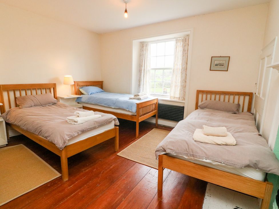 A bedroom with three single beds and a window at Covercote in Horsehouse near Leyburn