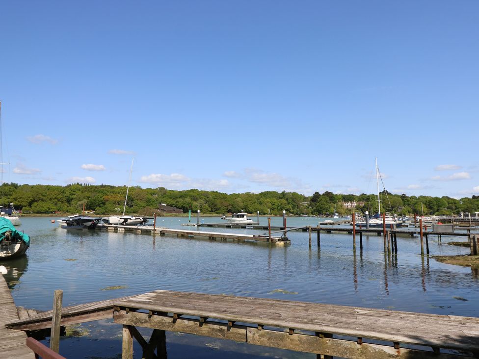 A harbour with boats docked at wooden piers and trees in the background at Byewater Ryde