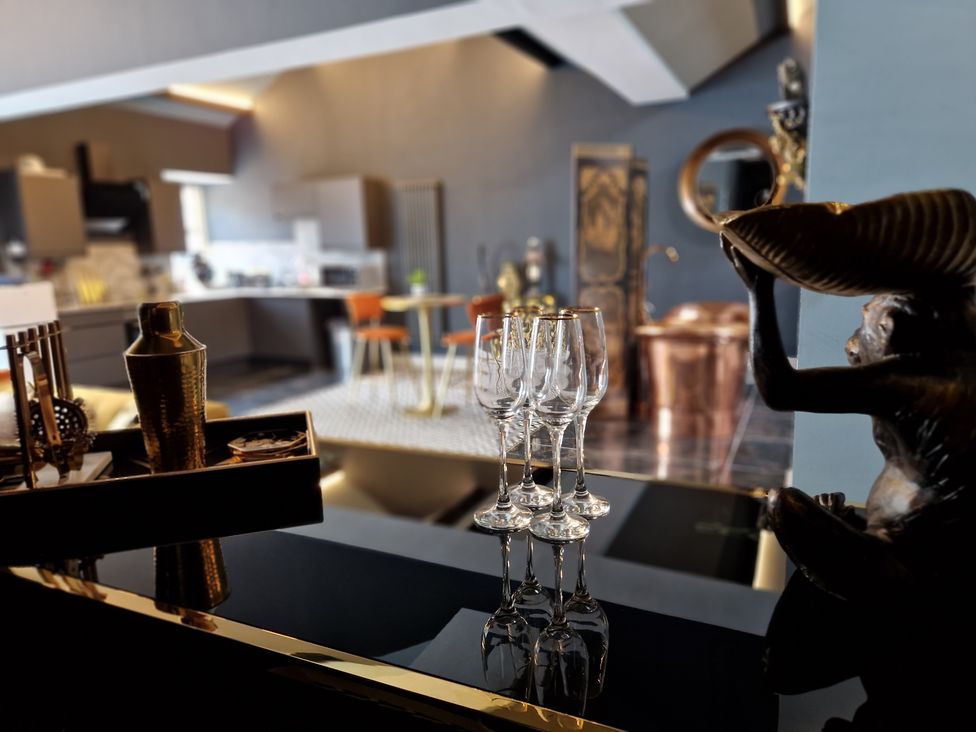 A kitchen and dining area with four wine glasses on a black reflective surface at The Studio in Cabus near Garstang