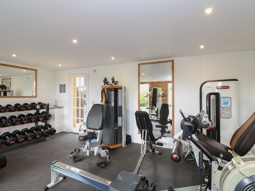 A gym room with dumbbells and exercise machines at Lodge 15 - The Tummel (Family) in Errol