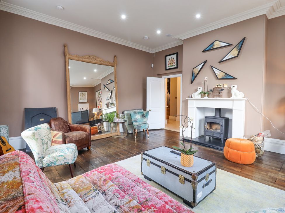 A living room with a large mirror fireplace and various chairs at 3 Old Market Place in Harleston