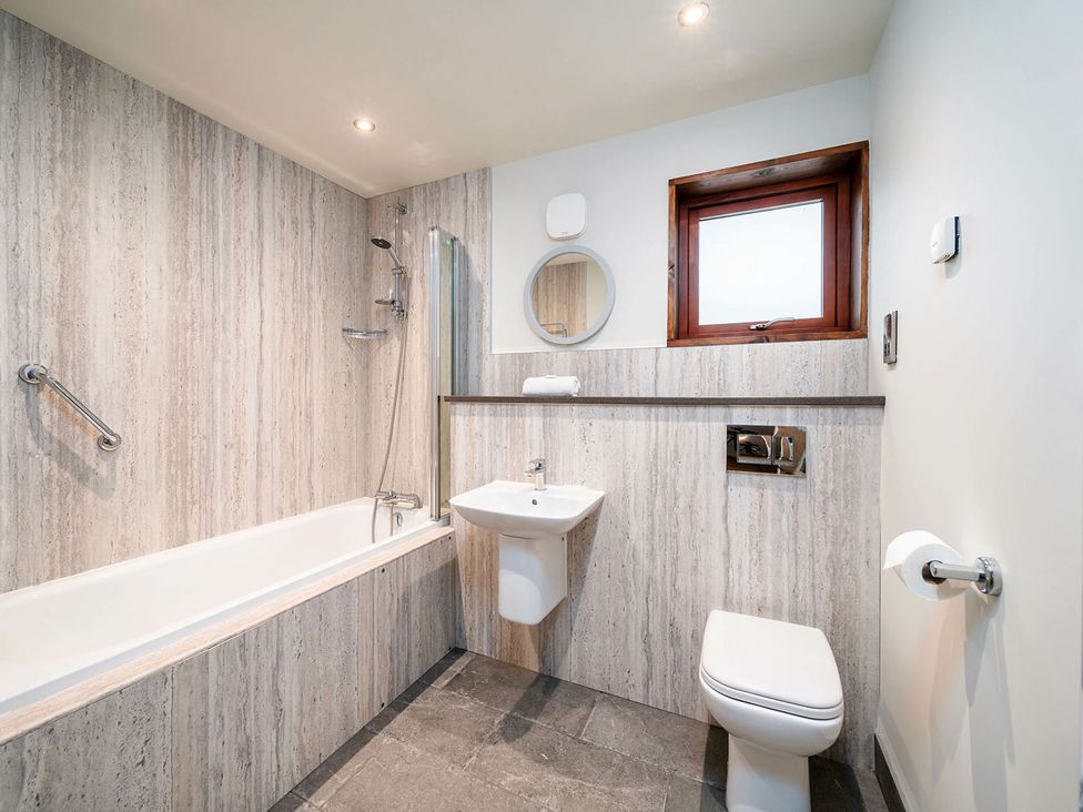 A bathroom with a bathtub shower sink toilet and a window at Glentress Forest Golden Oak Glentress Forest Peebles