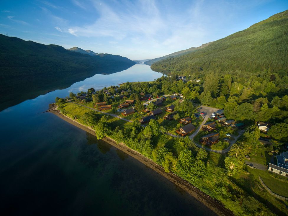 A lakeside village with wooden cabins surrounded by trees and hills at Ardgartan Argyll Golden Oak in Ardgartan Loch Long