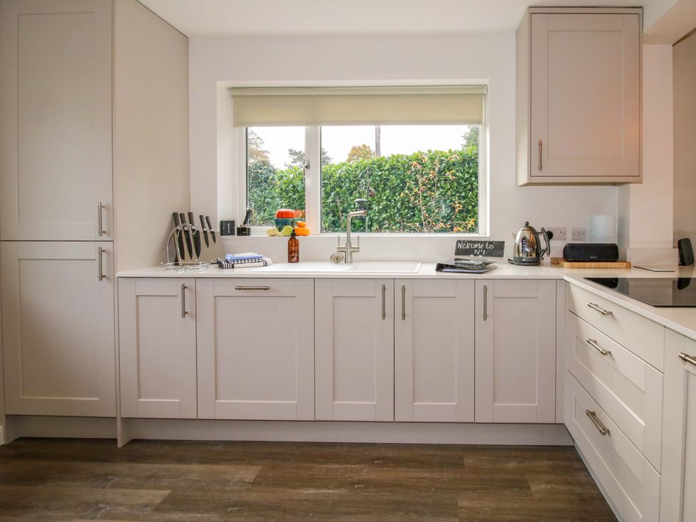 A kitchen with white cabinets and countertop a sink under a window and various items on the countertop at 1 Church Street in Church Stretton