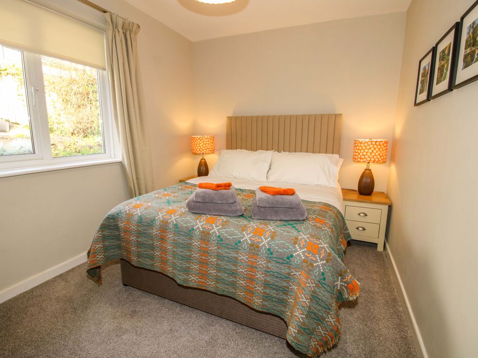 A bedroom with a double bed bedside tables with lamps window with curtains and framed pictures on the wall at 1 Church Street in Church Stretton