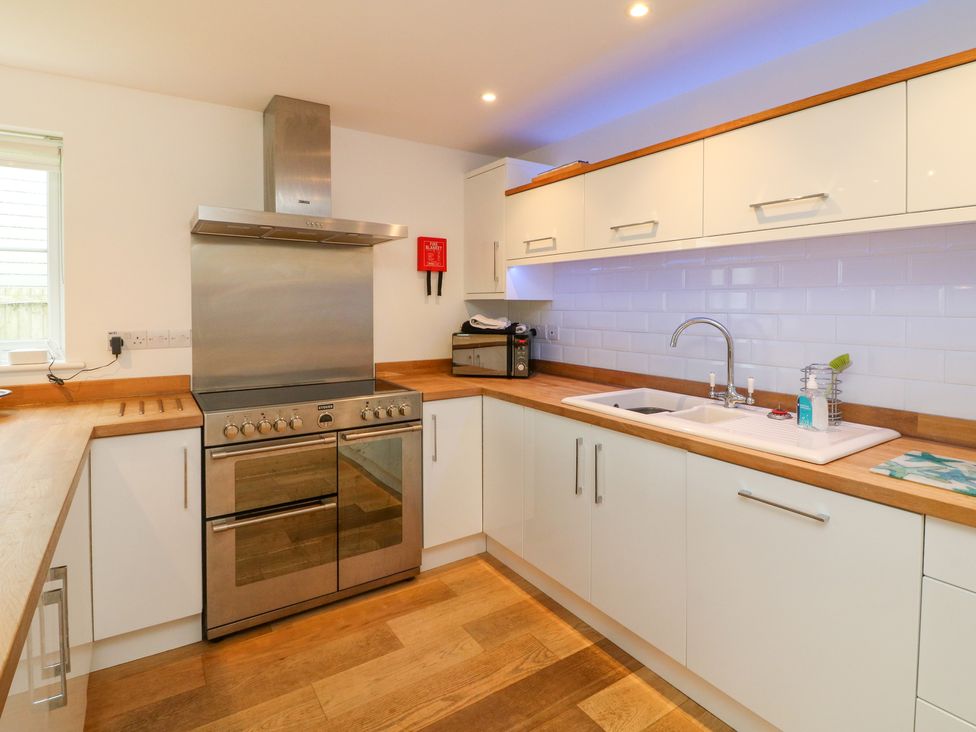 A kitchen with a stove oven sink and wooden countertops at 9 Coastguard Cottages in Woolacombe