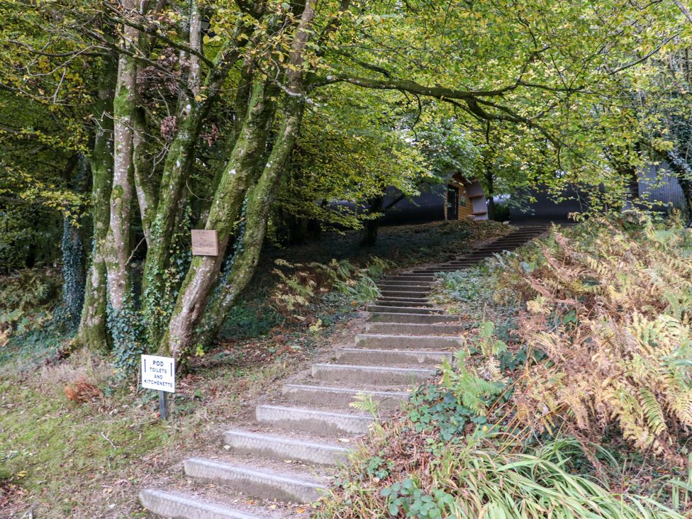 A set of outdoor steps leading through trees and plants to small pods with signs for pod toilets and kitchenette at Ballybeg Pod 7 Ballybeg near Tinahely County Wicklow