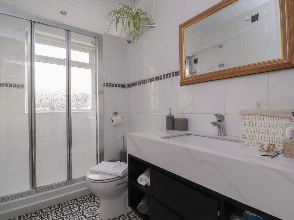 A bathroom with a shower enclosure toilet sink and mirror at Love Nest in Heysham
