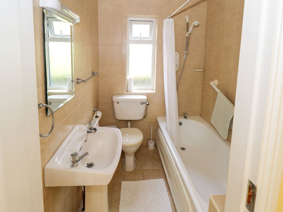 A bathroom with a sink mirror toilet bathtub and shower at Robins Roost 2 in Cornamona County Galway