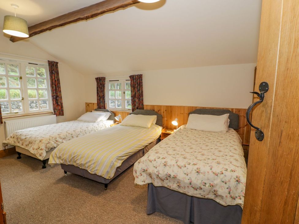 A bedroom with three single beds and two windows at Ysgubor in Dinas Mawddwy near Dolgellau