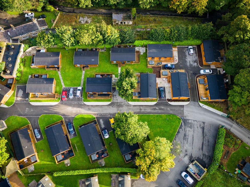 Aerial view of a small neighborhood with multiple houses green lawns and parked cars at Dovestone Pod 22 in Greenfield