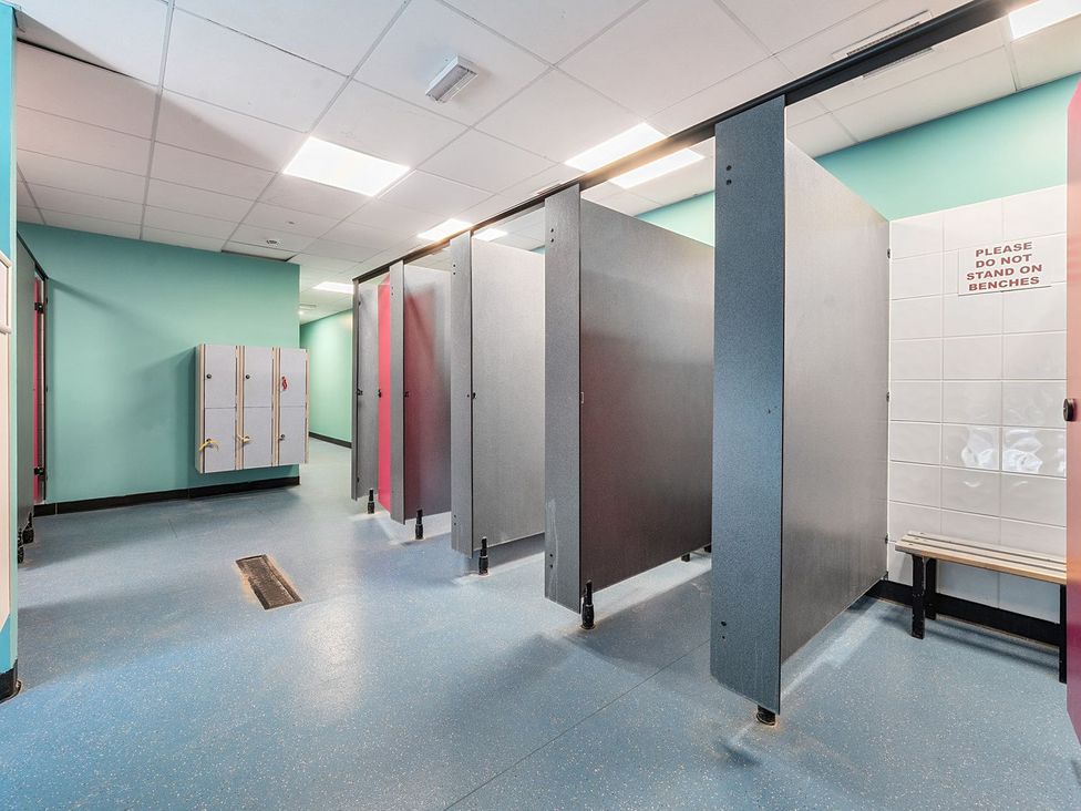 A changing room with lockers and toilet stalls at Blue Flag Shores - Hayling Island