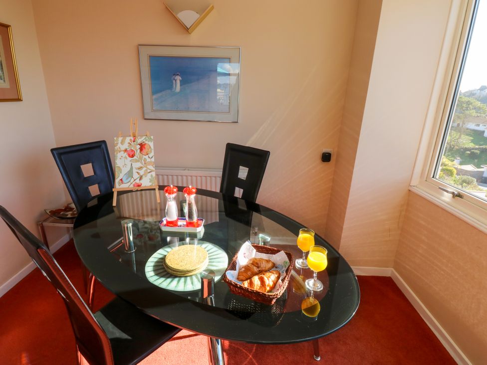 A dining room with a glass table two glasses of orange juice and a basket with croissants at Rosa in Torquay