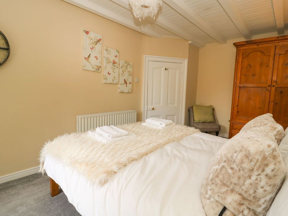 A bedroom with a bed and white towels on a furry blanket at St Edmunds House in Crakehall