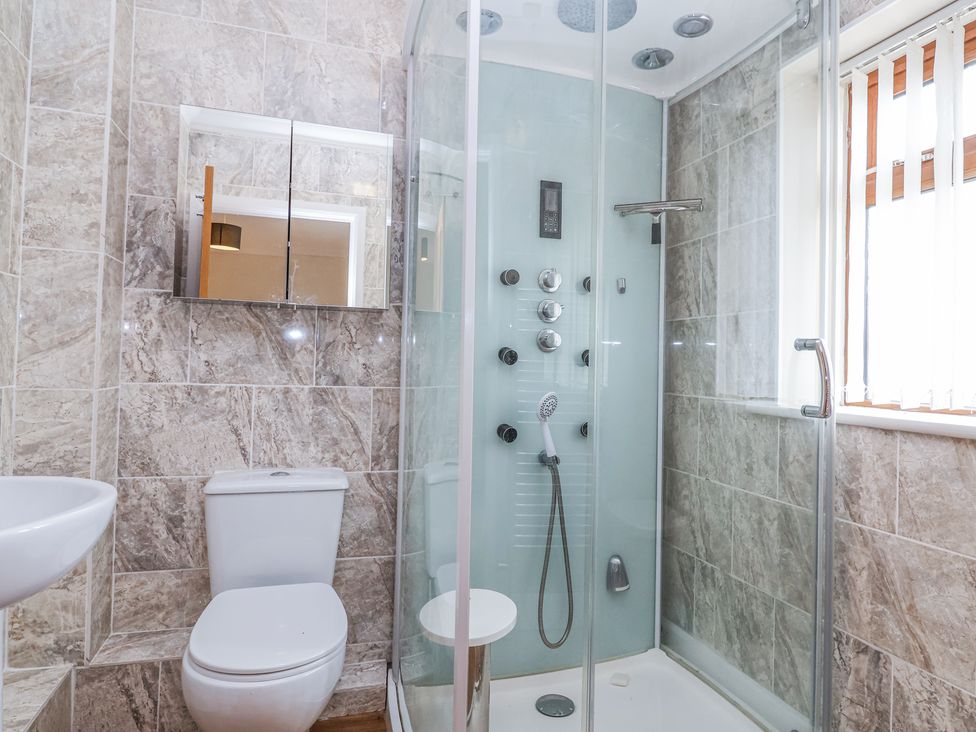 A bathroom with a toilet sink glass shower enclosure and a wall-mounted mirror cabinet at Stapleton Farm Bungalow Damerham near Alderholt