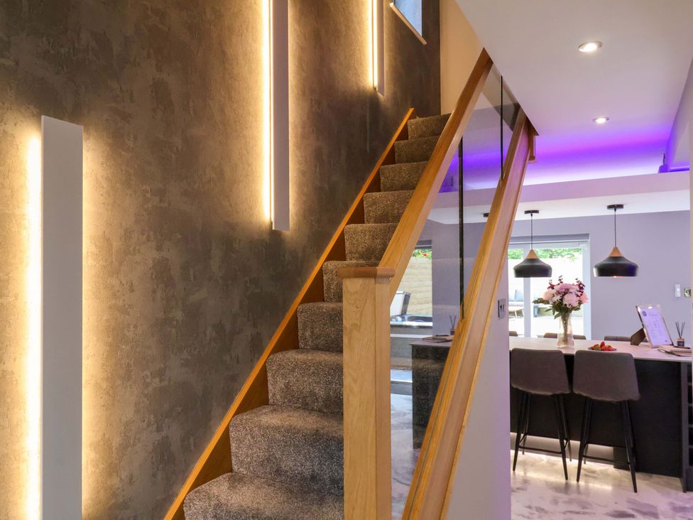 A staircase with a wall and light fixtures at 12 Hunley Avenue Brotton near Saltburn-By-The-Sea