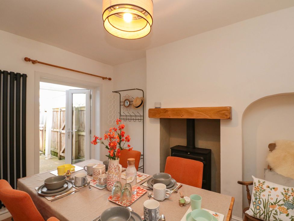 A dining room with a table set for a meal at Moot Cottage in Driffield