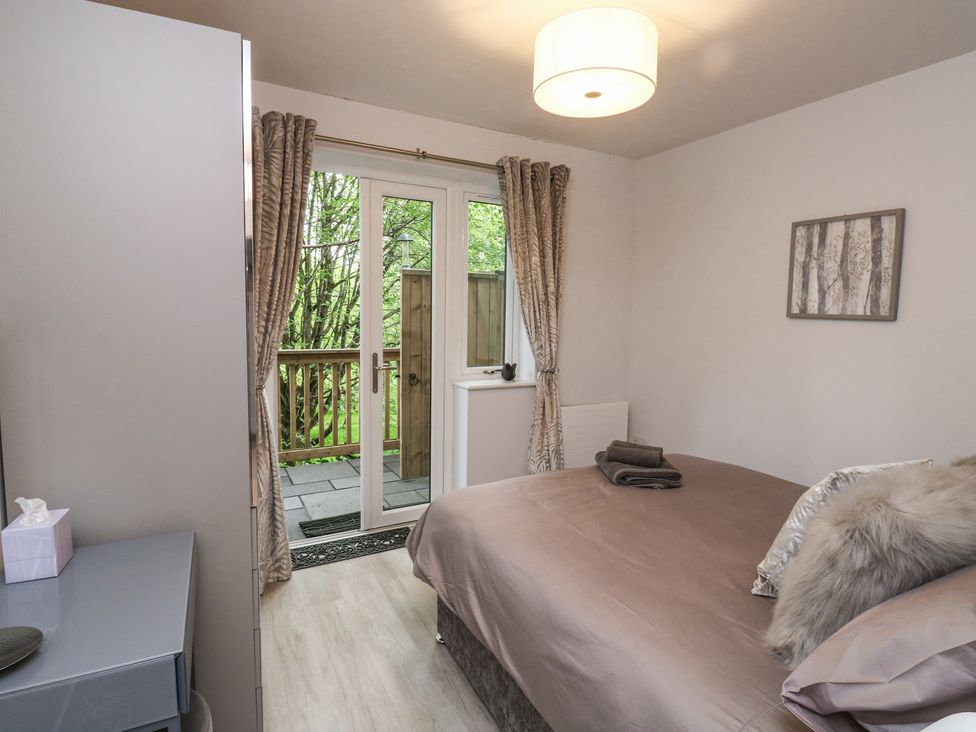 A bedroom with a bed towels and pillows next to glass doors leading to a balcony at Treetops in Southerton
