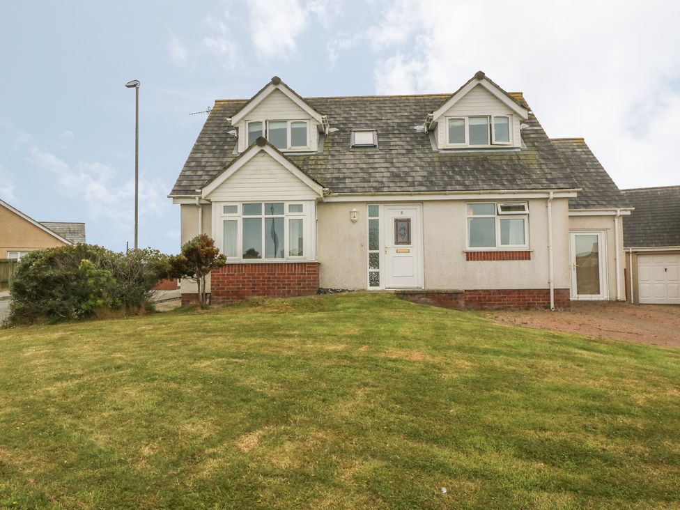 A detached house with dormer windows and a front lawn at 5 Cae Derwydd in Cemaes Bay