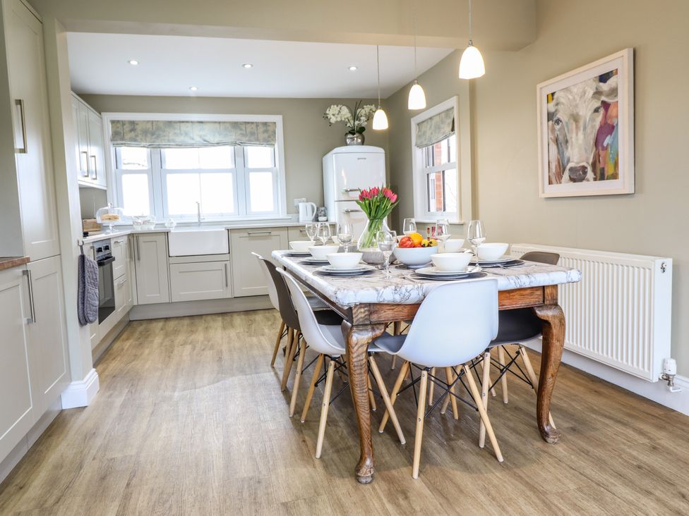 A kitchen with a dining table set with bowls and glasses and chairs at Red House Farm in Llanfair Caereinion near Welshpool