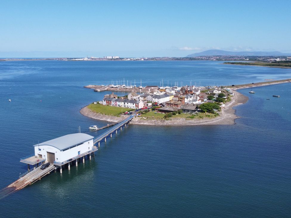 An aerial view of a small island with houses a pier and boats in the water at Roa Island House in Roa Island