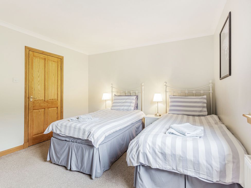 A bedroom with two single beds and bedside table lamps at Askival in Elgol