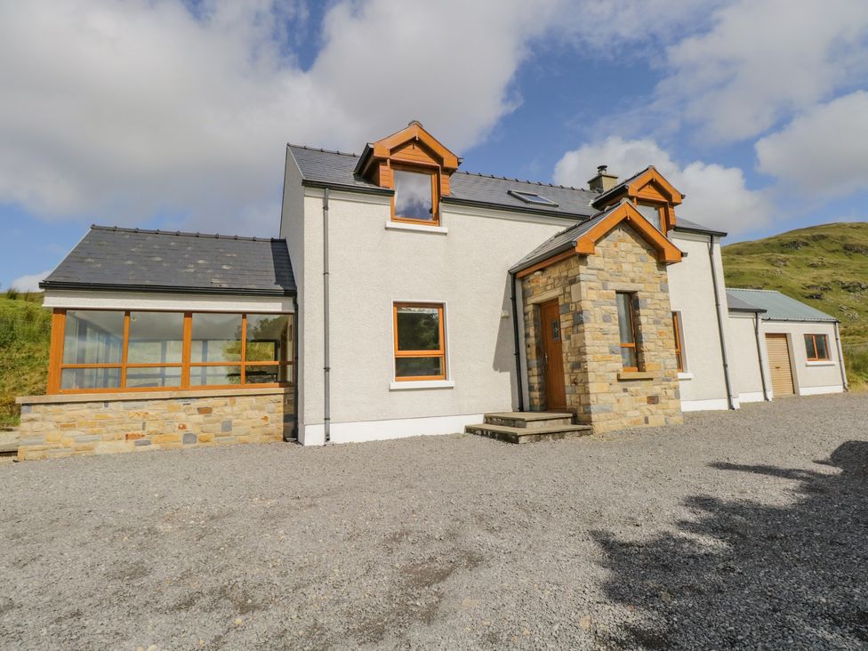 An exterior view of a two-story house with stone and white plaster walls and wooden framed windows at Blue Stack House in Meenaguish Beg near Donegal Town County Donegal