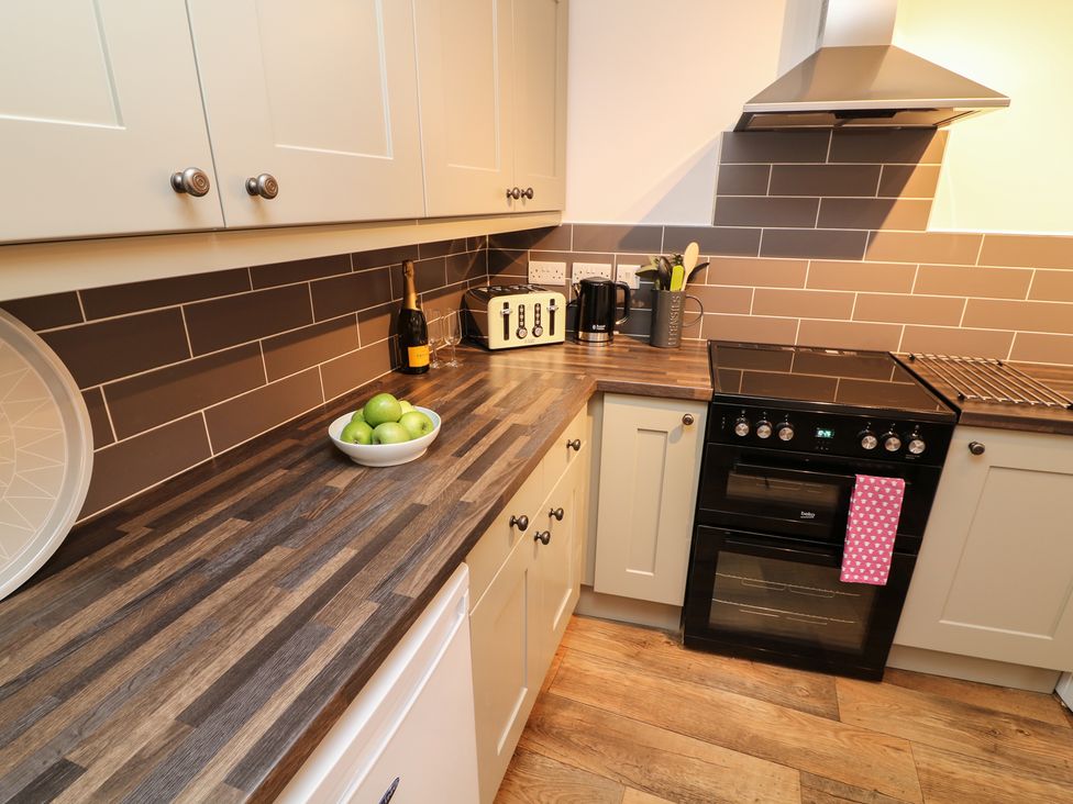 A kitchen with a stove oven kettle toaster and bowl of green apples at Whitefriars Lodge in Settle