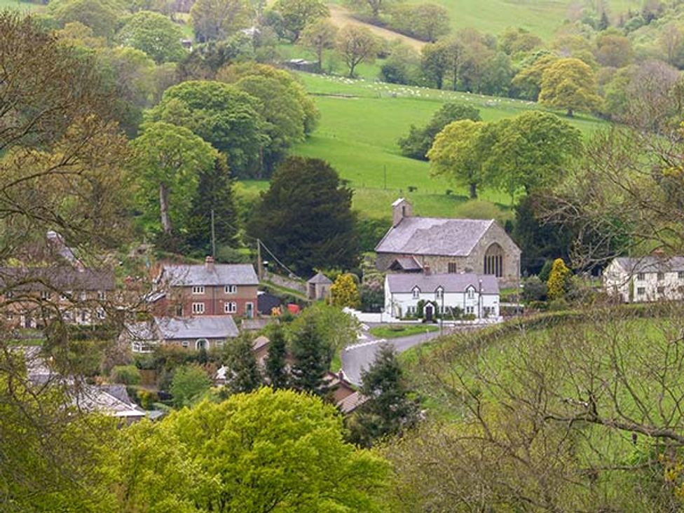 A village with houses and a church surrounded by green fields and trees at Tyn Y Celyn Uchaf in Clocaenog near Ruthin