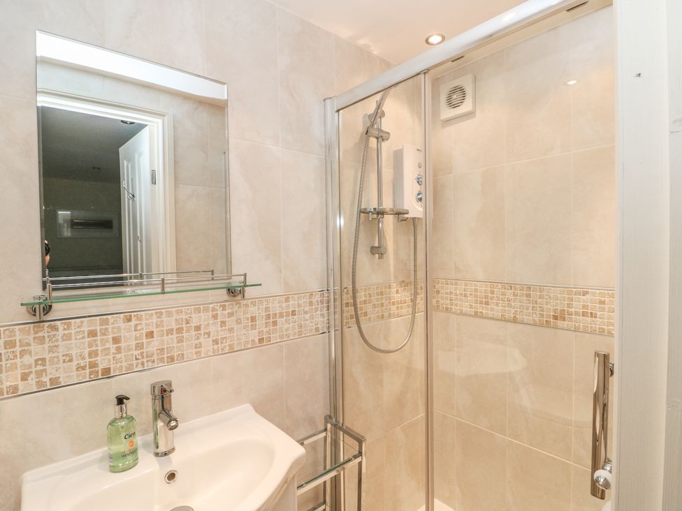 A bathroom with a sink and mirror and a glass enclosed shower at Badger View in Culverstone Green near Chatham