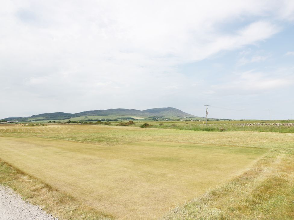 An open field with mowed grass and hills in the background at Cheri in Southerness