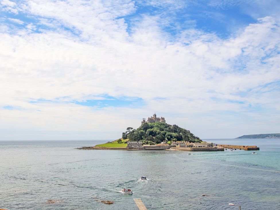 A small island with a castle on top surrounded by water with boats near the shore at Rose Villa in Newlyn