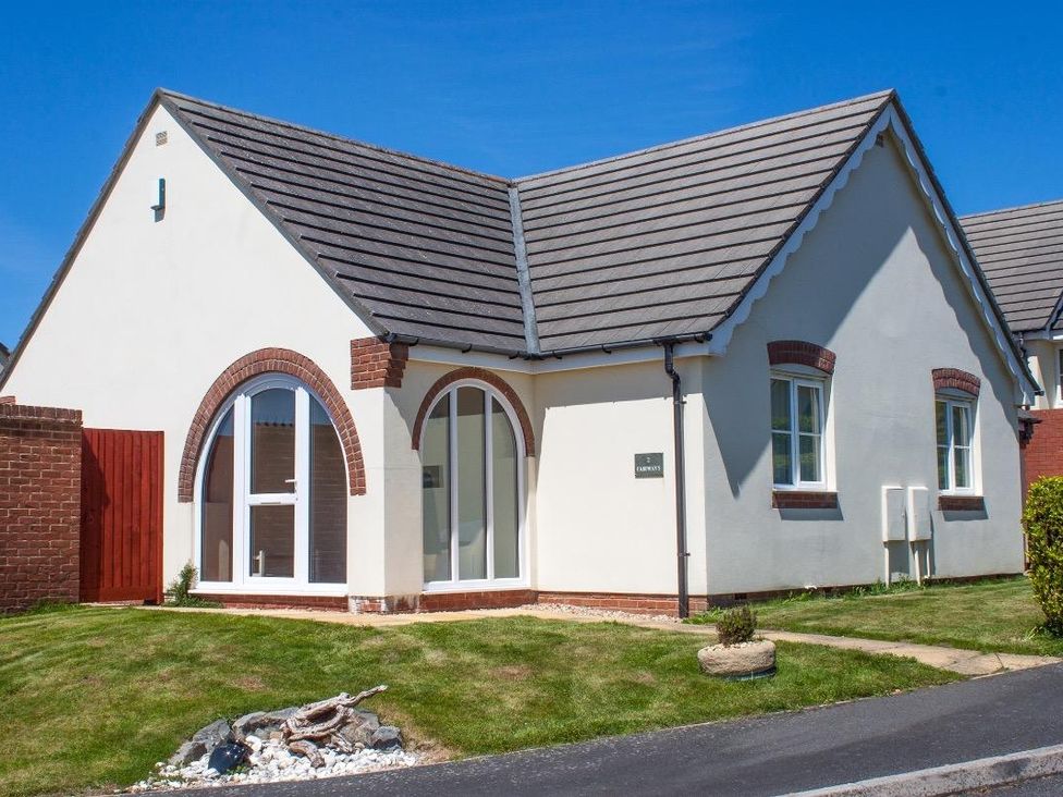 View of a single-story house with arched windows and a tiled roof at Fairways in Woolacombe