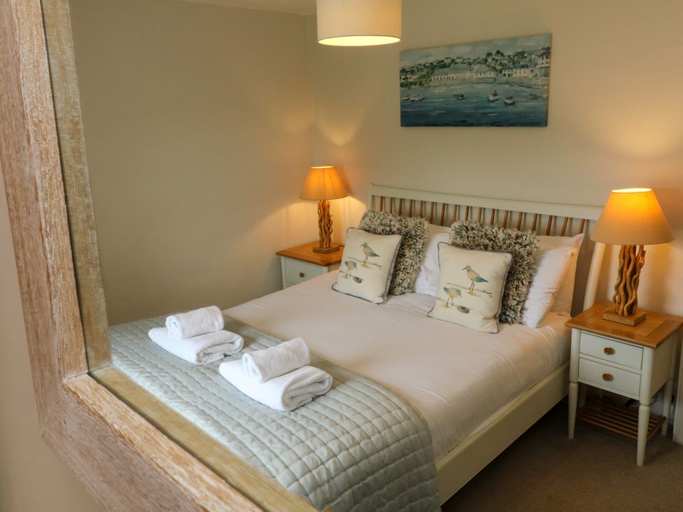 A bedroom with a bed with pillows and folded towels on a quilt at Pheasant Cottage in Ilfracombe