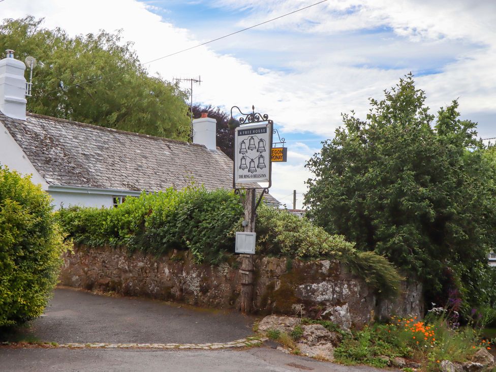 A sign in front of a building with greenery at Little Gate Cottage North Bovey