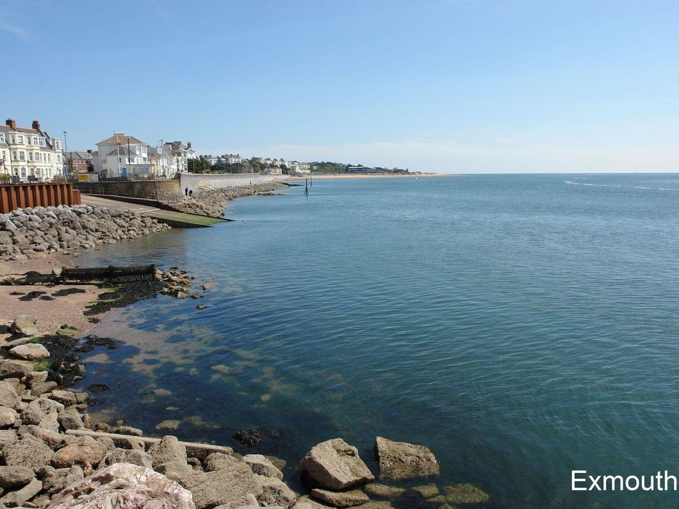 A coastal view with rocky shoreline and buildings along the edge at 2 Carlton Mews in Exmouth
