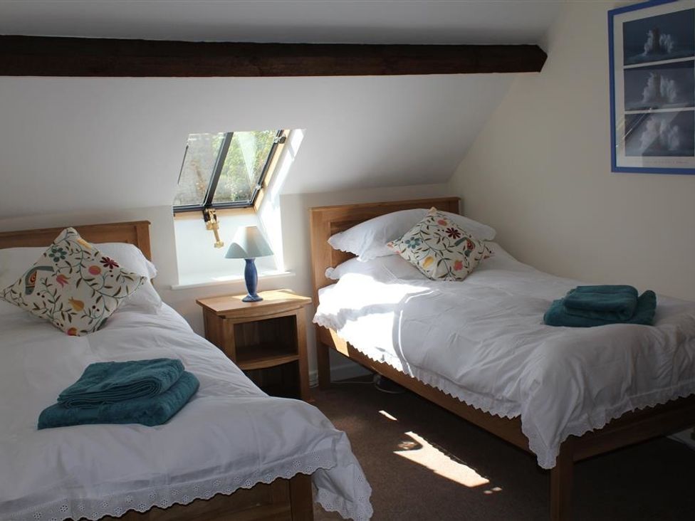 A bedroom with two single beds pillows side table and lamp at Droop Farm Cottage Droop near Hazelbury Bryan