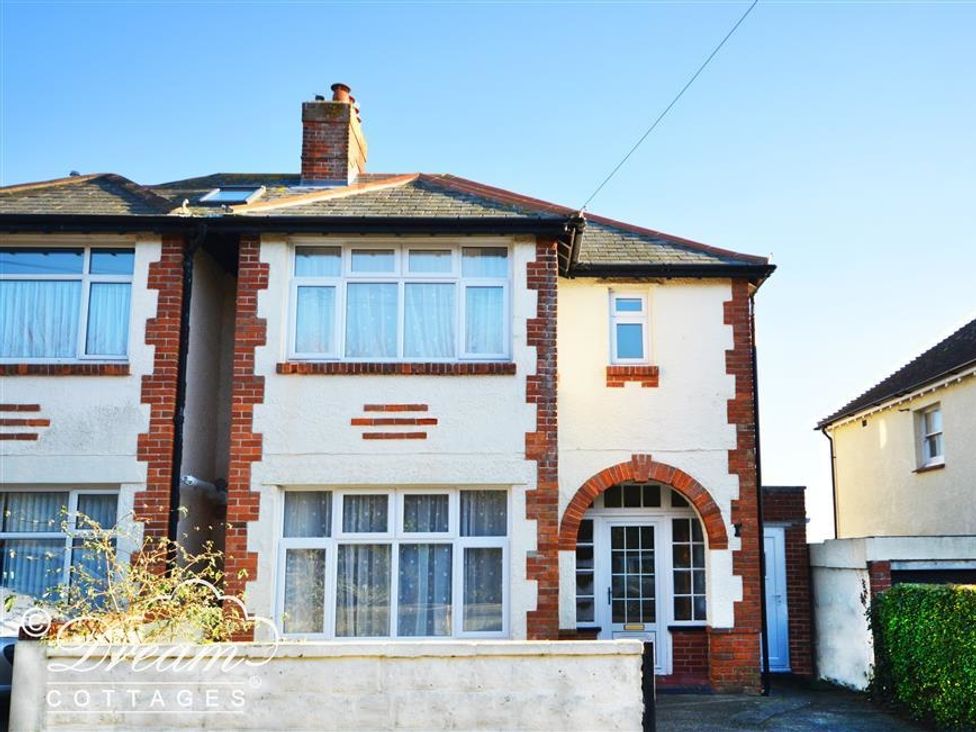 A semi detached house with brick and white exterior and large windows at Rainbow's End in Cove Castle