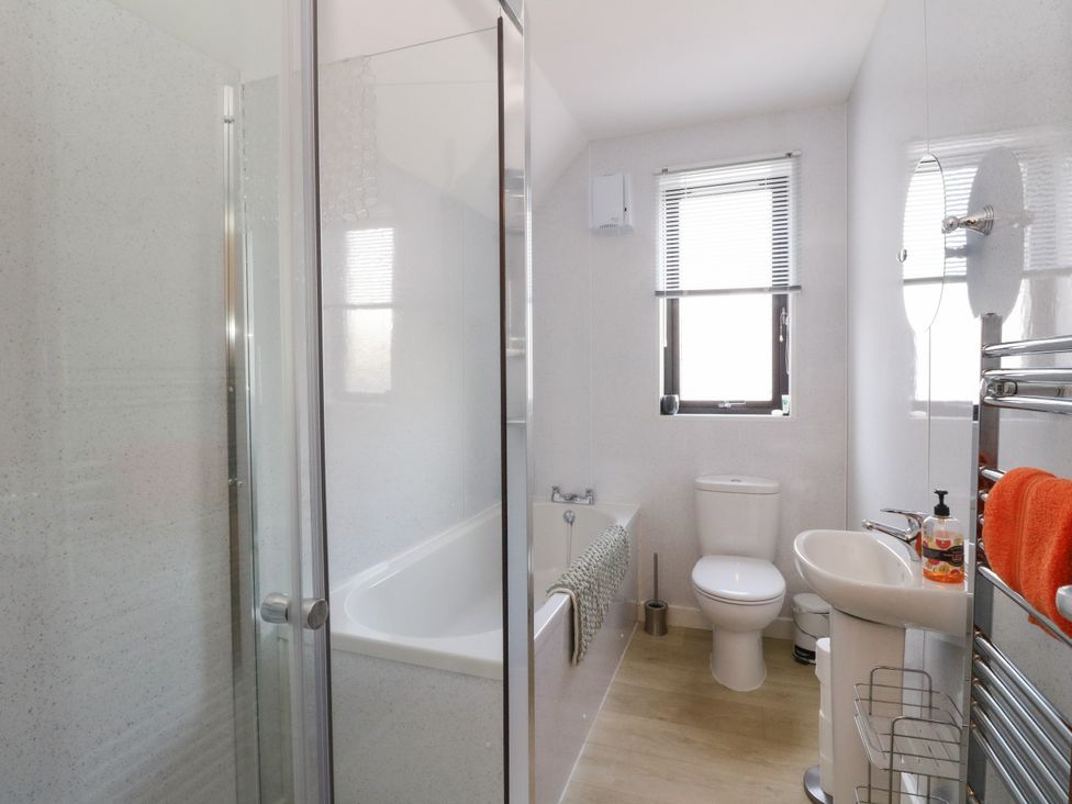 A bathroom with a shower enclosure bathtub toilet sink and towel rack at 6 Aonachan Gardens Spean Bridge near Fort William