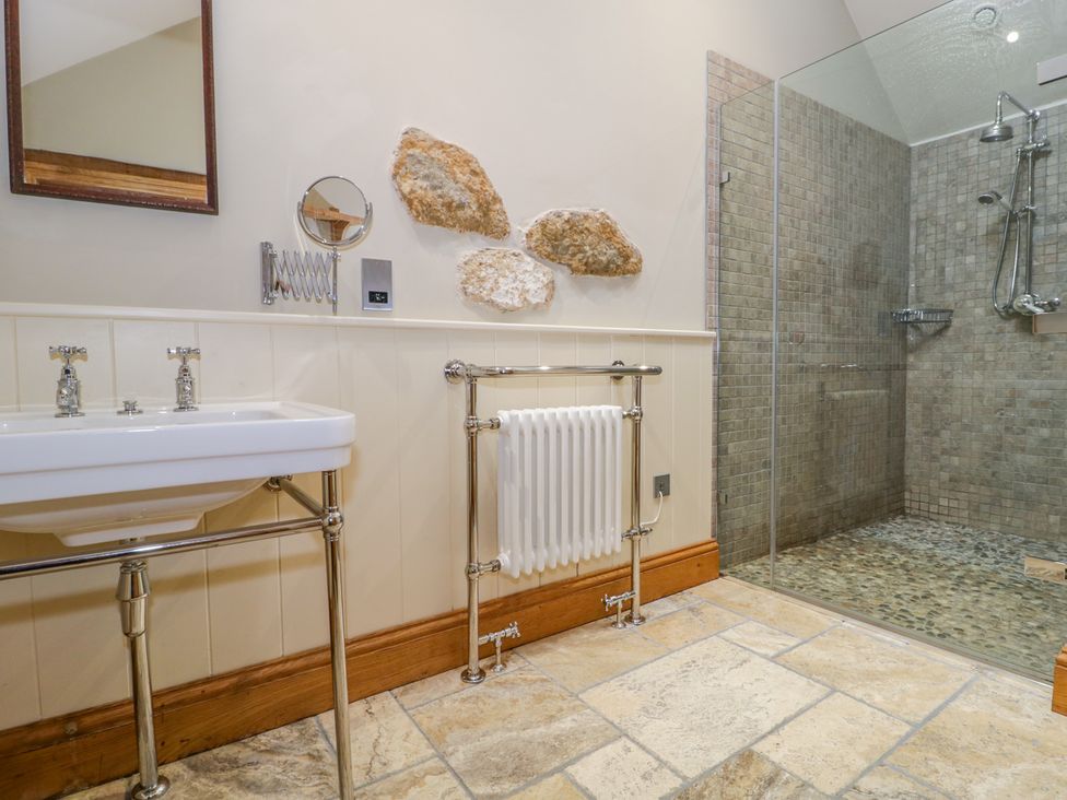 A bathroom with a sink a mirror a towel radiator and a walk in shower at Middle Farm Annex in Long Bredy