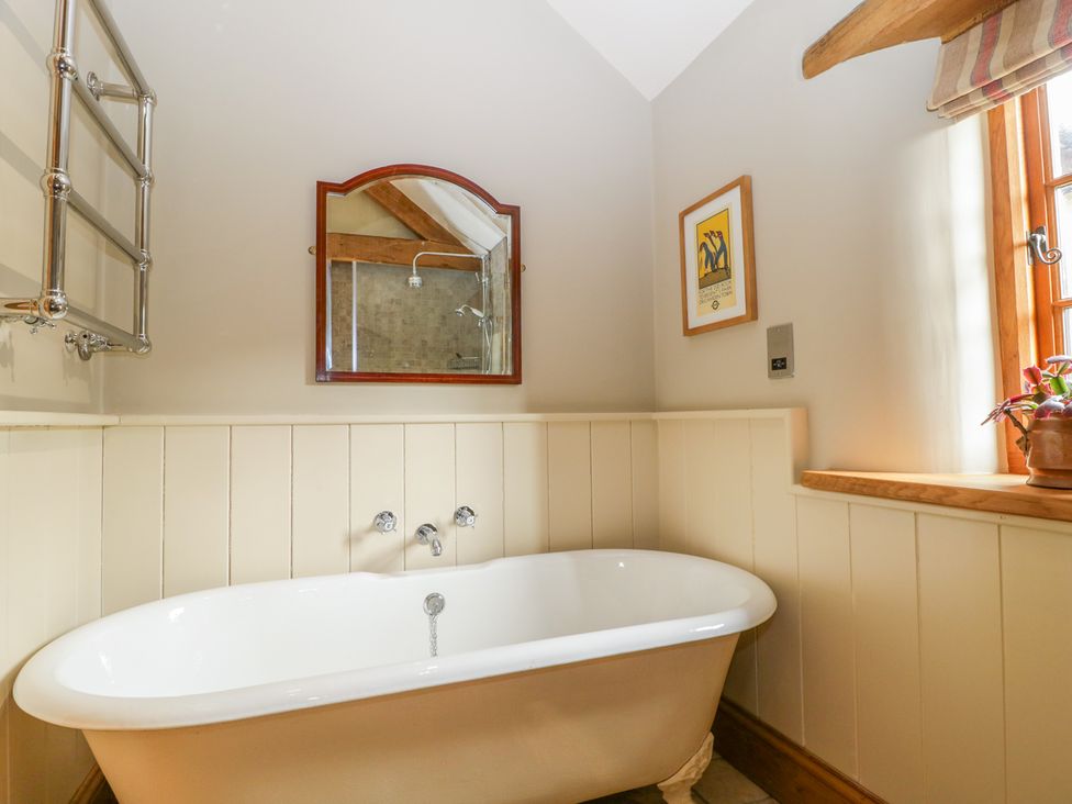 A bathroom with a freestanding bathtub mirror and window at Middle Farm Annex in Long Bredy